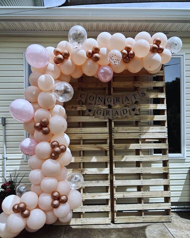 Peach and rose gold garland over a rustic pallet backdrop, built by Sherri's Heavenly Balloons in central Indiana.