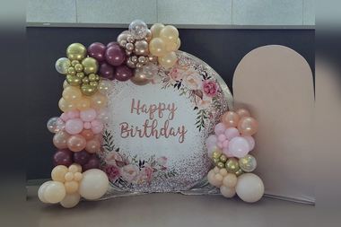 Blush, plum and gold garland around a floral round backdrop, built by Sherri's Heavenly Balloons in central Indiana.