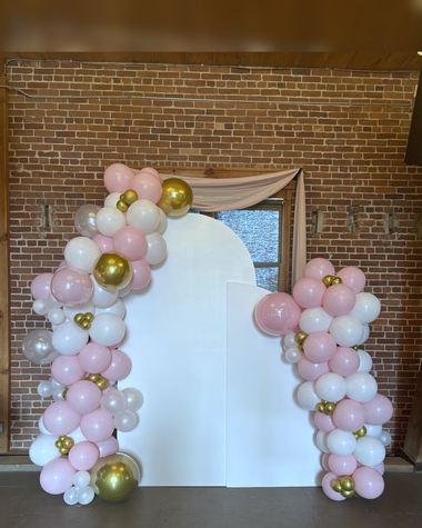 Blush, pearl and gold garland on an arch panel against brick, built by Sherri's Heavenly Balloons in central Indiana.