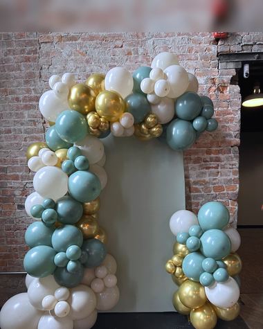 Sage, gold and cream garland over an exposed brick fireplace, built by Sherri's Heavenly Balloons in central Indiana.